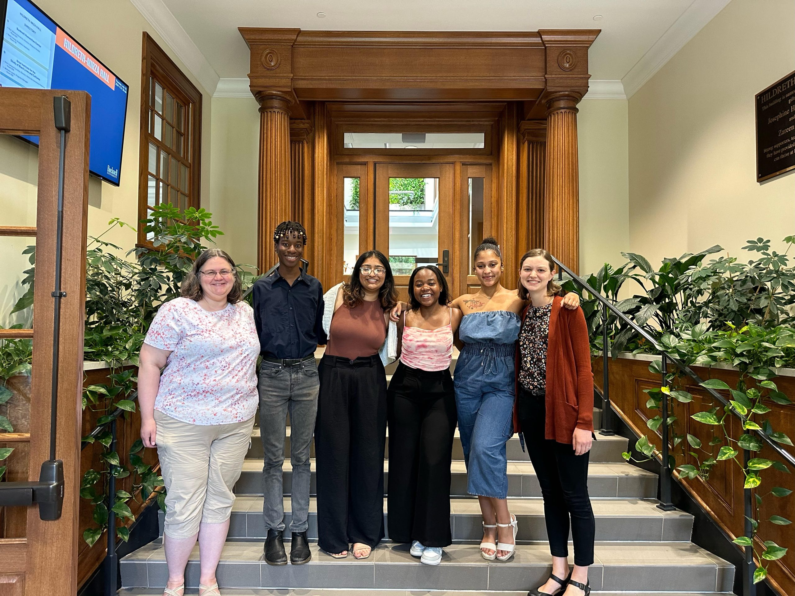 The DSSRF 2024 cohort and facilitators standing together after their final presentations in the Hildreth-Mirza Humanities Center, smiling.